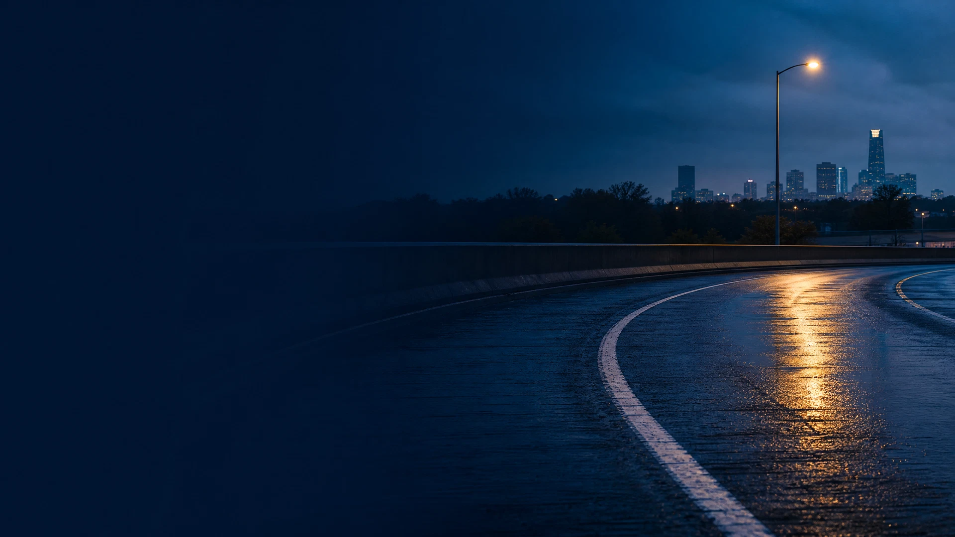 Quiet Oklahoma roadway at wet blue hour, representing leaving-the-scene legal questions